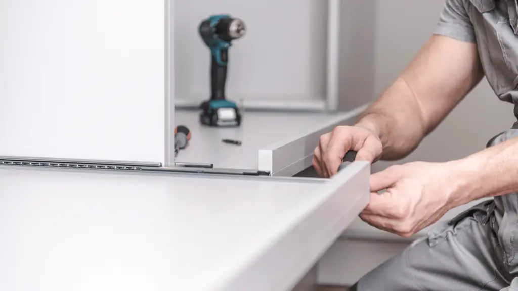 Handwerker montiert einen Kleiderschrank – Fachgerechte Demontage und Montage für Umzüge"